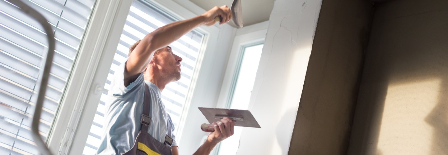 A person applying lime plaster to a ceiling.