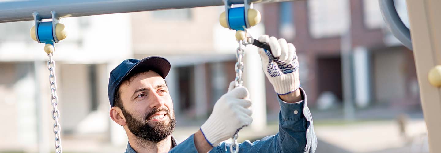 A swingset being fixed by a handyman