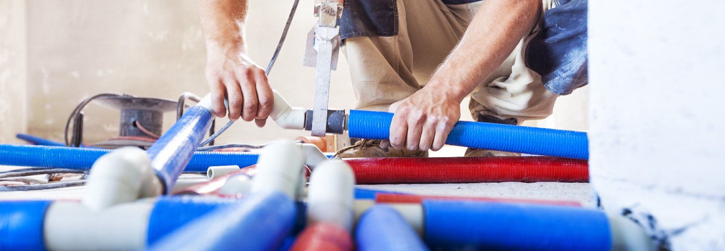 A close-up photo of a person repairing a PVC pipe.