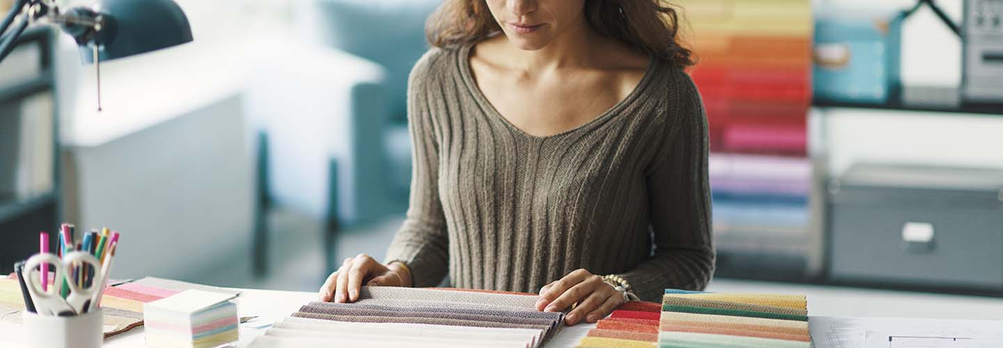 A person in stylishly decorated office space with modern furniture,deciding on a color from a set of palettes.