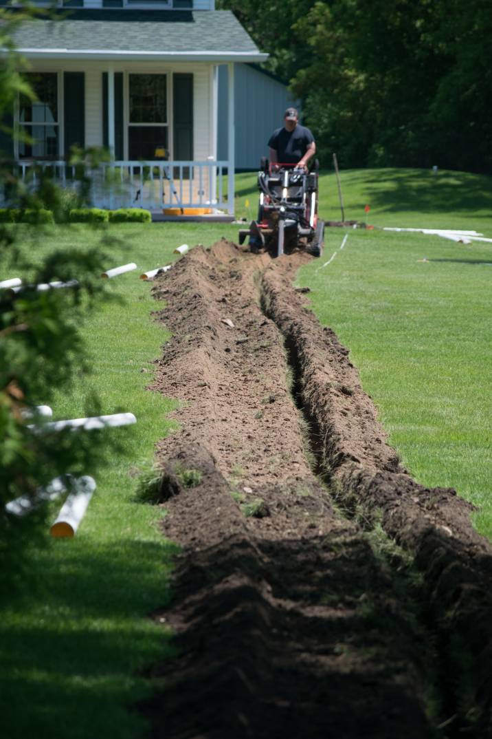 a man digging a shallow trench