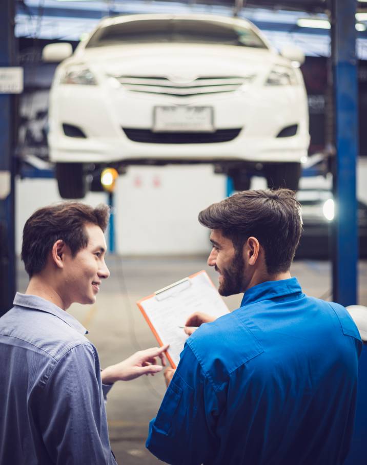 a male customer talking to a mechanic about his car