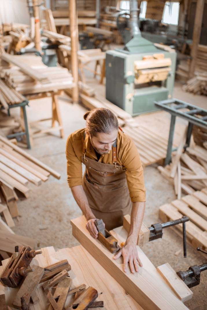 a carpenter sanding a plank of wood