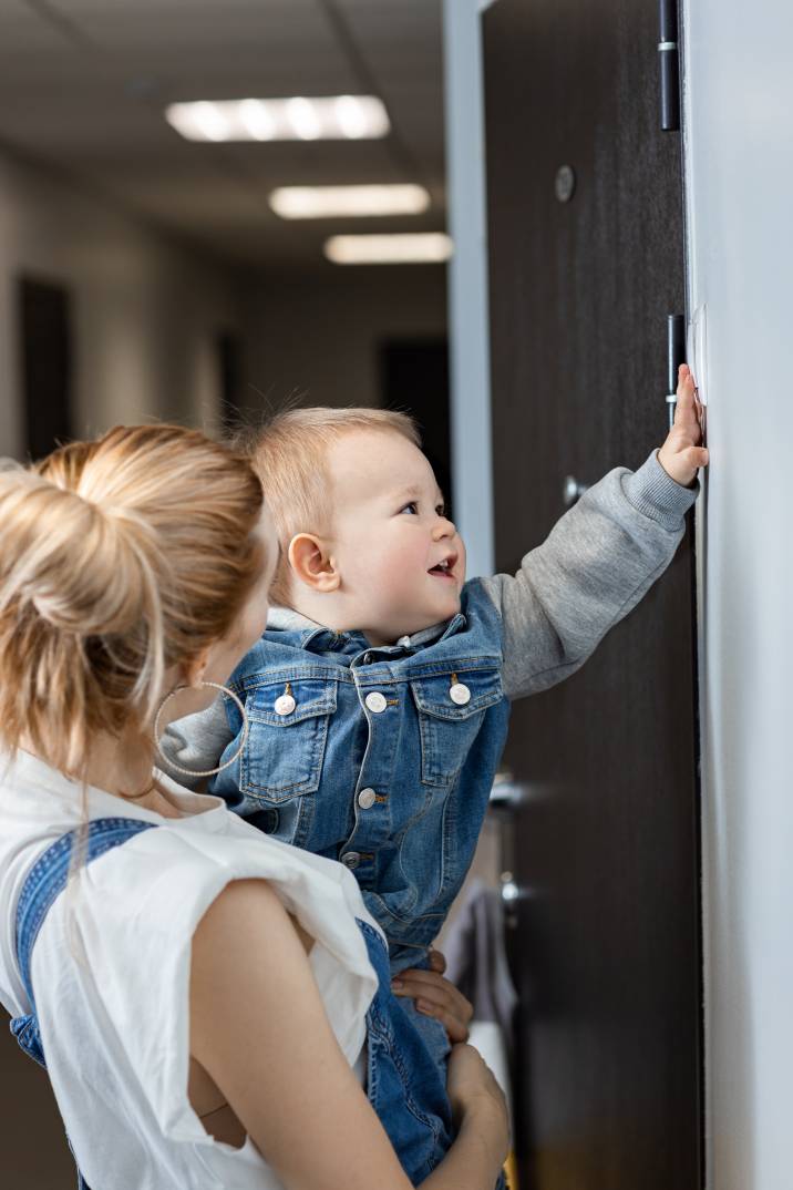 a woman and her baby ringing a doorbell