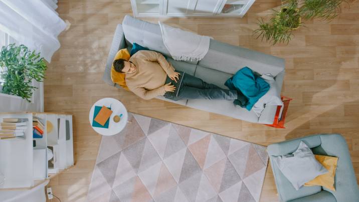 man lying down on sofa in self-contained garden room