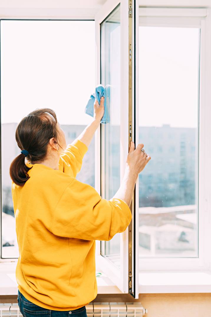 a woman cleaning an apartment window