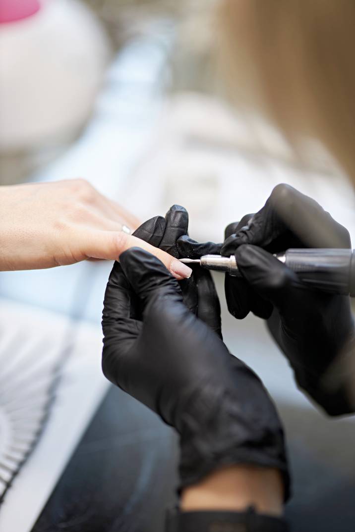 a beautician applying nail polish