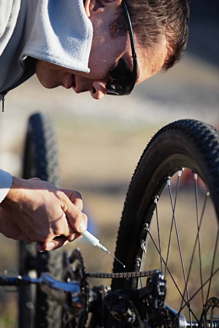 a man lubricating a bicycle chain