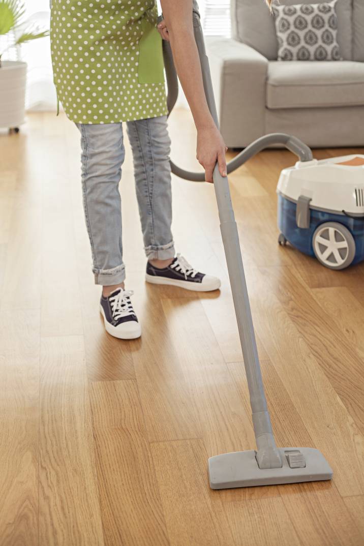 a woman cleaning a wooden floor