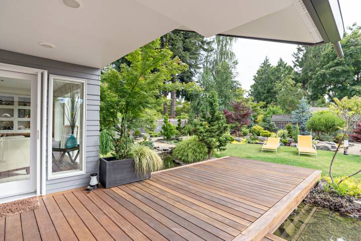 a house with a deck leading to a pond