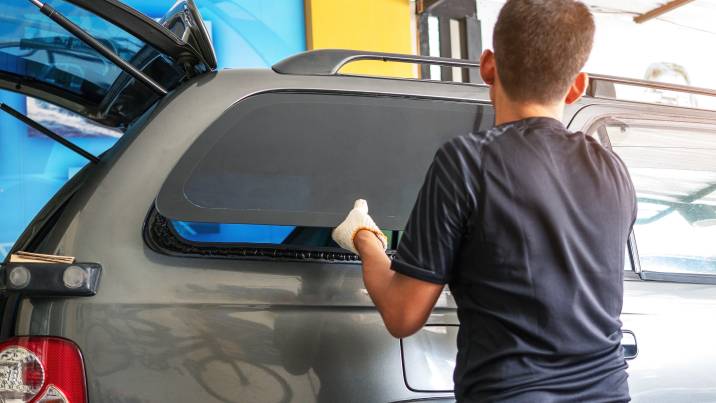 an auto technician replacing a car window