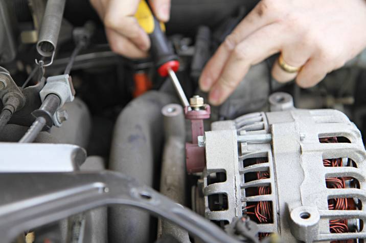 a mechanic installing a new alternator