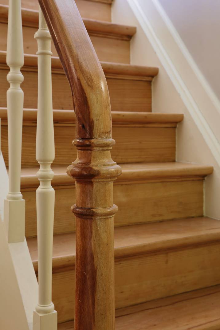 a straight wooden staircase in a house