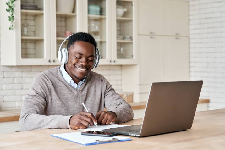 Man wearing headphones while writing a podcast script, scriptwriting to make money 