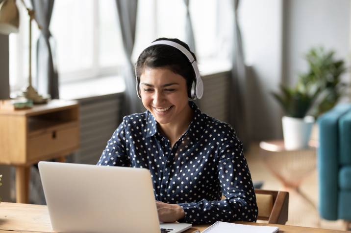 Young woman teaching English online, wearing headphones