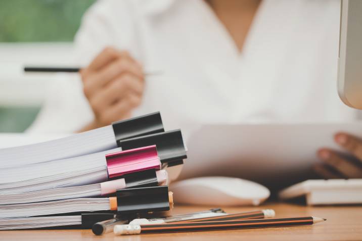 Part-time admin job. Teacher checking pile of accounting documents during her spare time