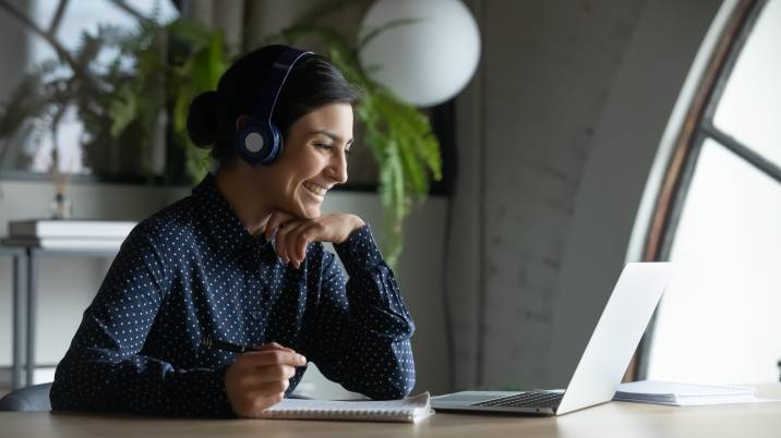 female employee in wireless earphones talk on video call