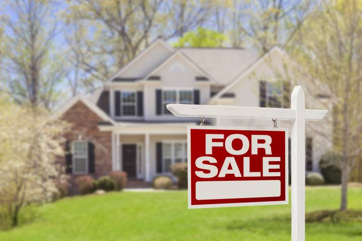 for sale sign in front of a house