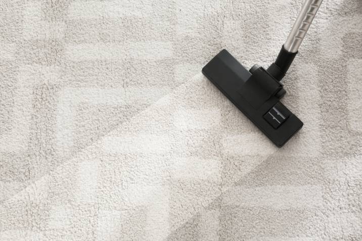 vacuuming dusty carpet