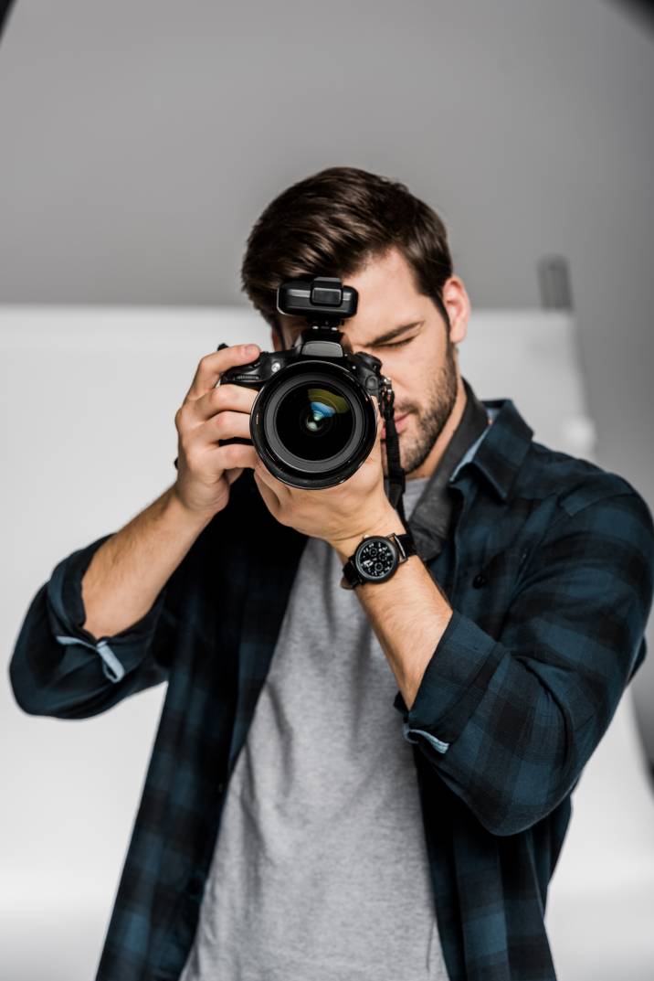 a headshot photographer holding a large camera