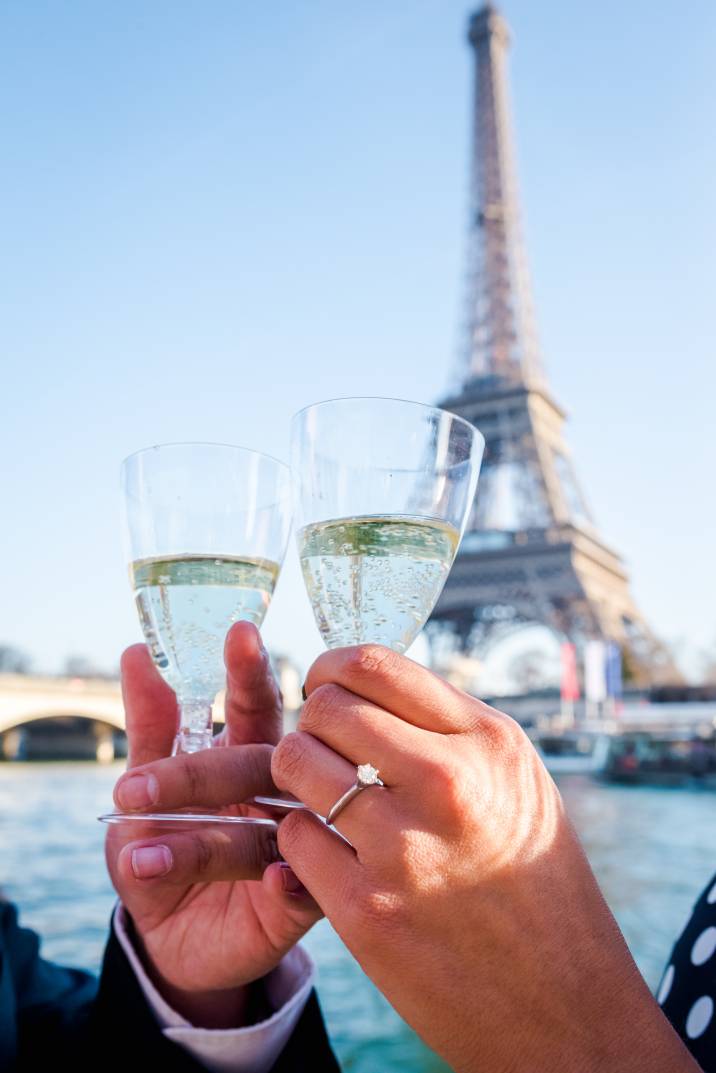 a newly engaged couple sharing a toast near the Eiffel Tower