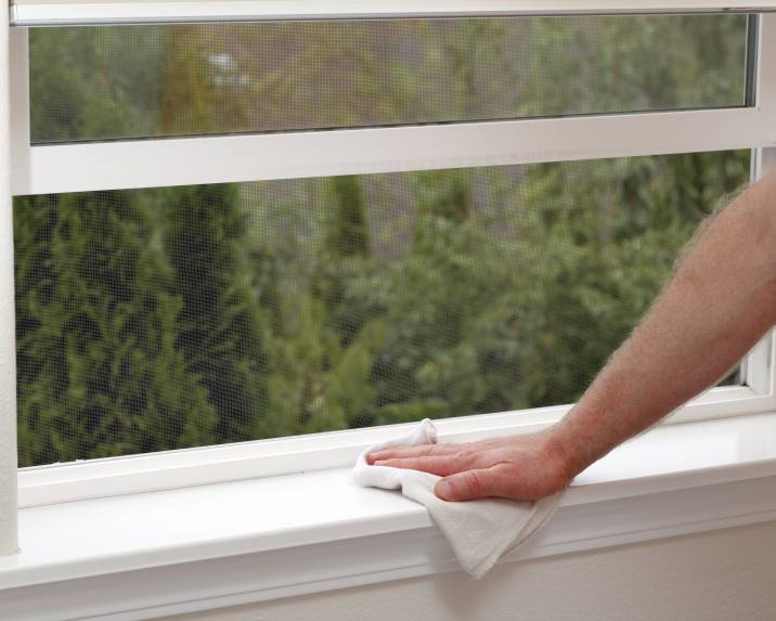 dusting window sill with cloth