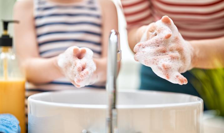 kid and adult washing their hands