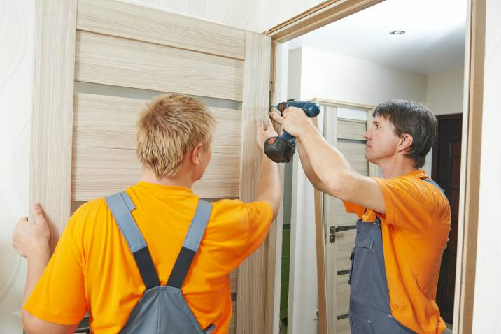 handymen installing a new door frame