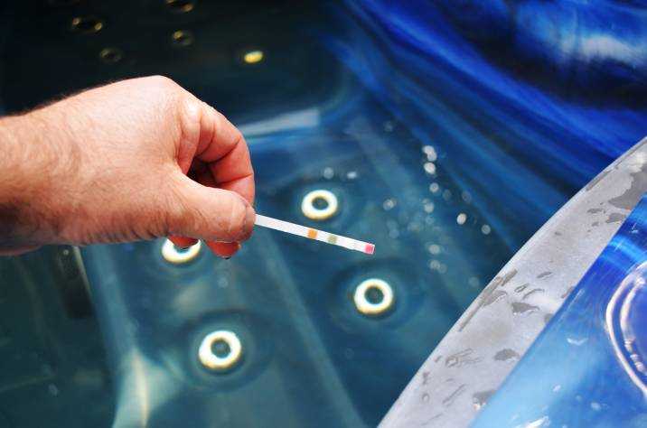 person testing hot tub water