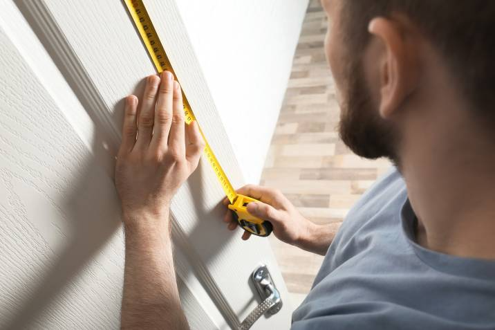 man measuring a door frame