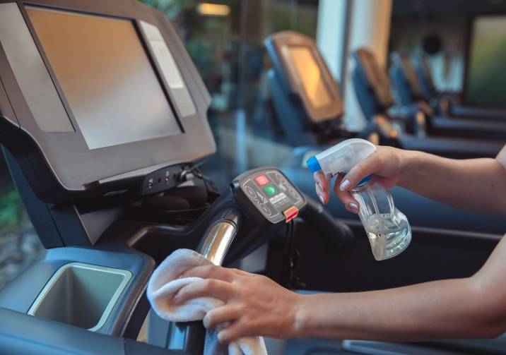 person cleaning a treadmill