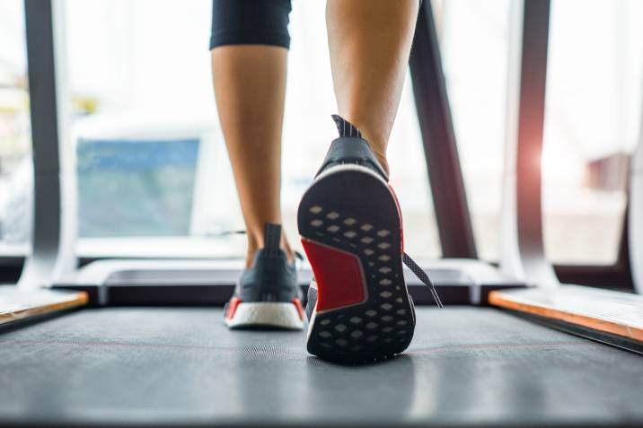 person walking on the treadmill to test belt tension