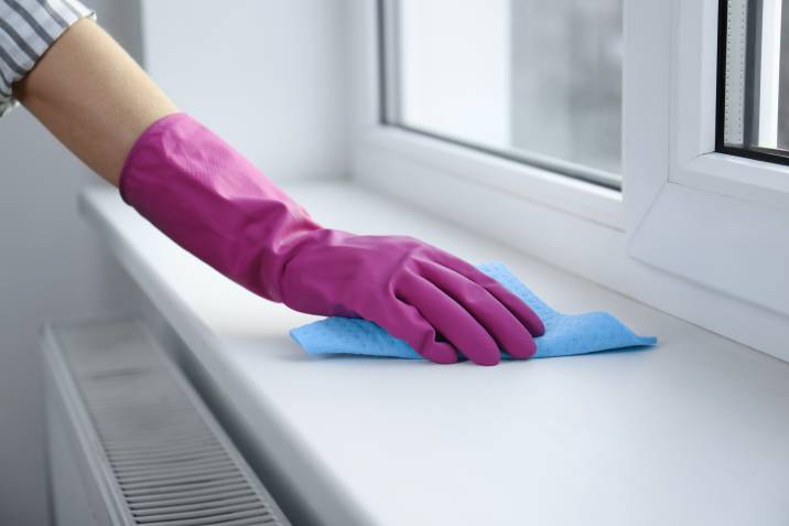 wiping window sill with microfiber cloth