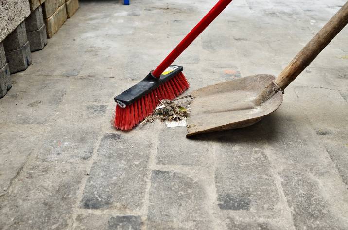 shovel and broom, sweeping trash and debris from garage floor