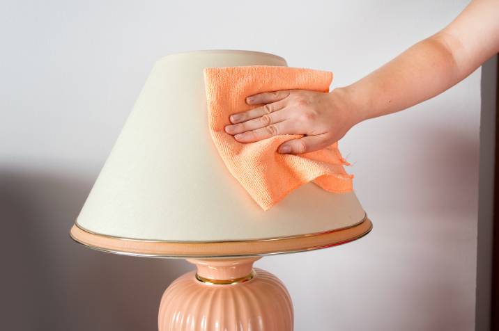 woman hand wiping fabric lamp shade
