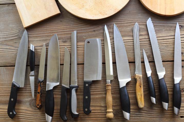 various kitchen knives lined up on table for packing