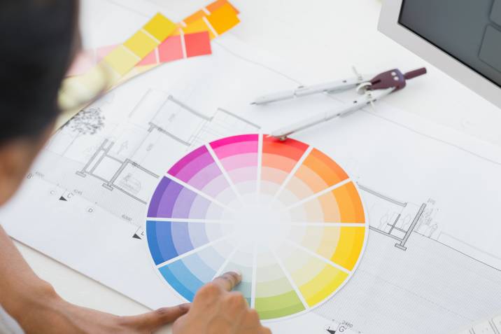 Person looking at color wheel at desk for apartment color inspiration