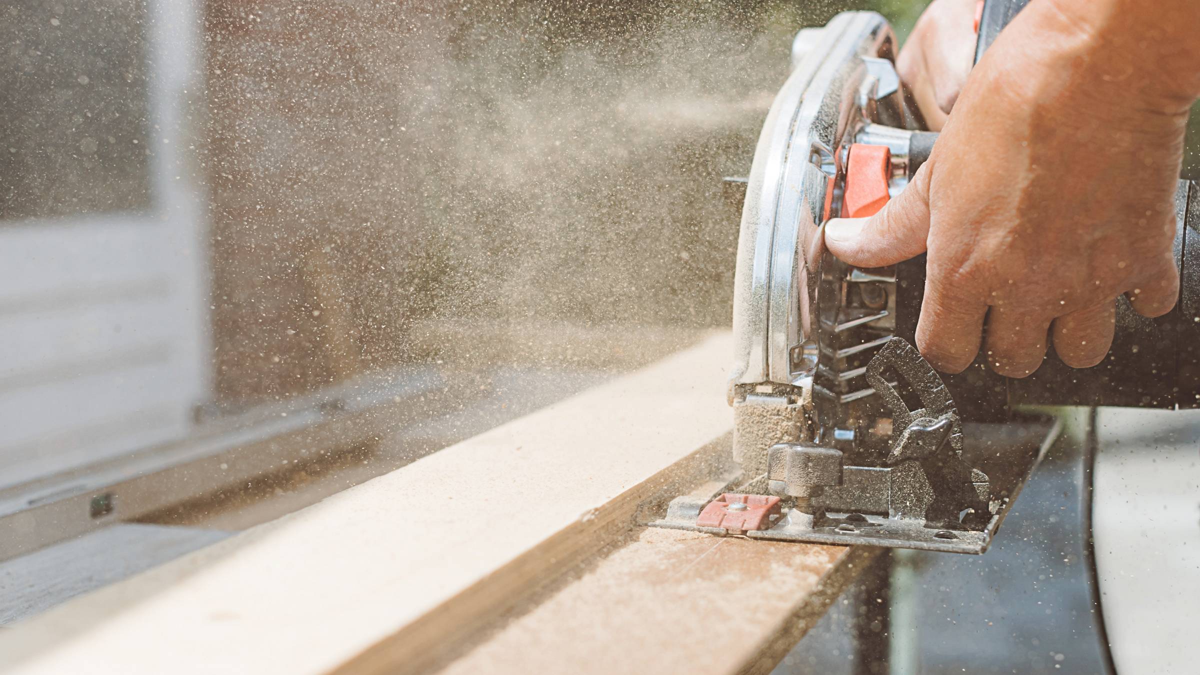 A carpenter using a circular power saw for cutting wood