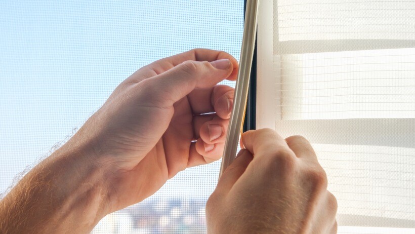 foam weather stripping vs vinyl: a man installing a vinyl weather stripping for noise insulation