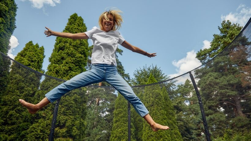 rectangle vs round trampoline: young female jumping on a trampoline outdoor
