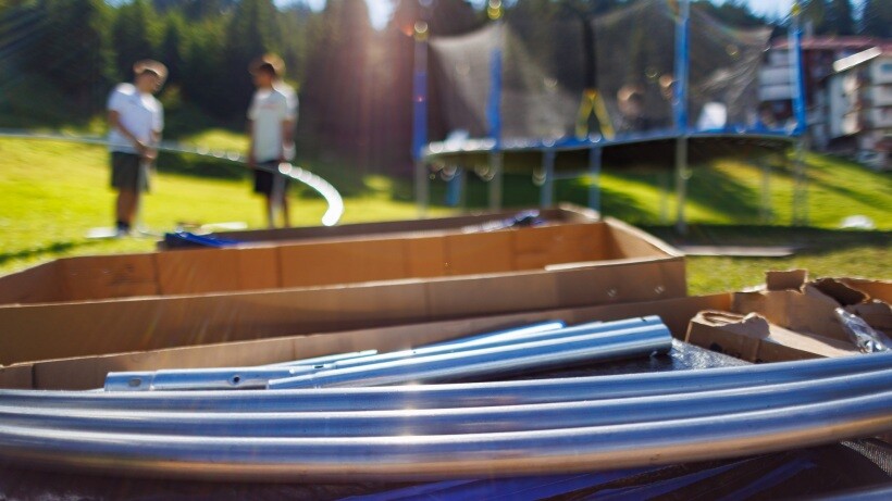 rectangle vs round trampoline: large cardboard boxes with iron beams and other kit to assemble a netted trampoline 