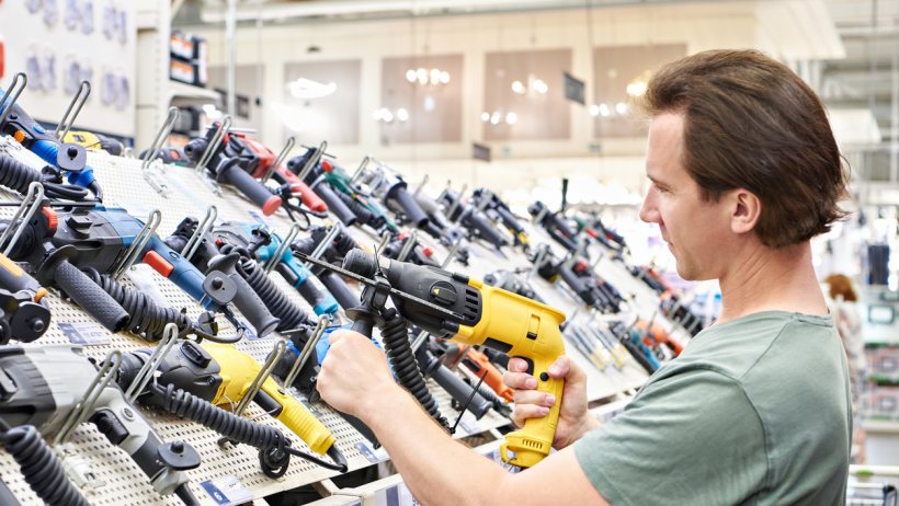 Nail gun vs staple gun - A handyperson shopping a nail gun or staple gun in a hardware store 