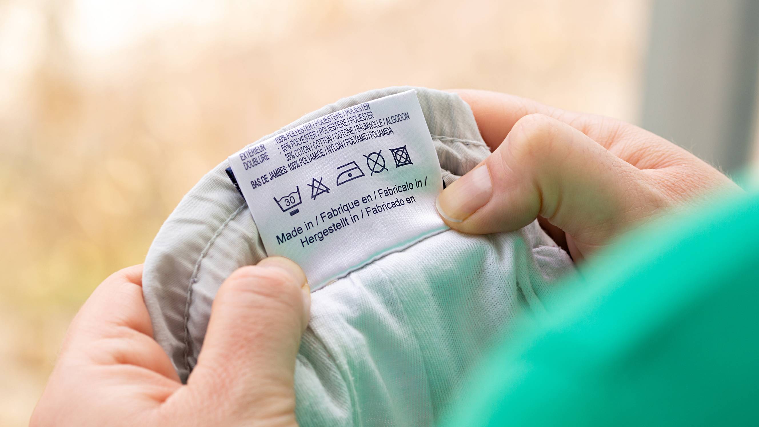 a woman checking a fabric's washing and dry cleaning compatibility