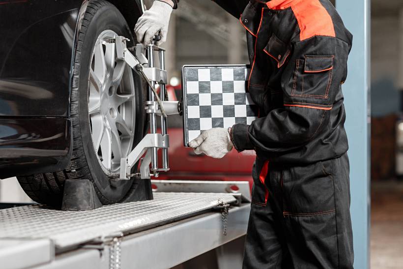 tire balancing vs. alignment - a mechanic performing tire alignment