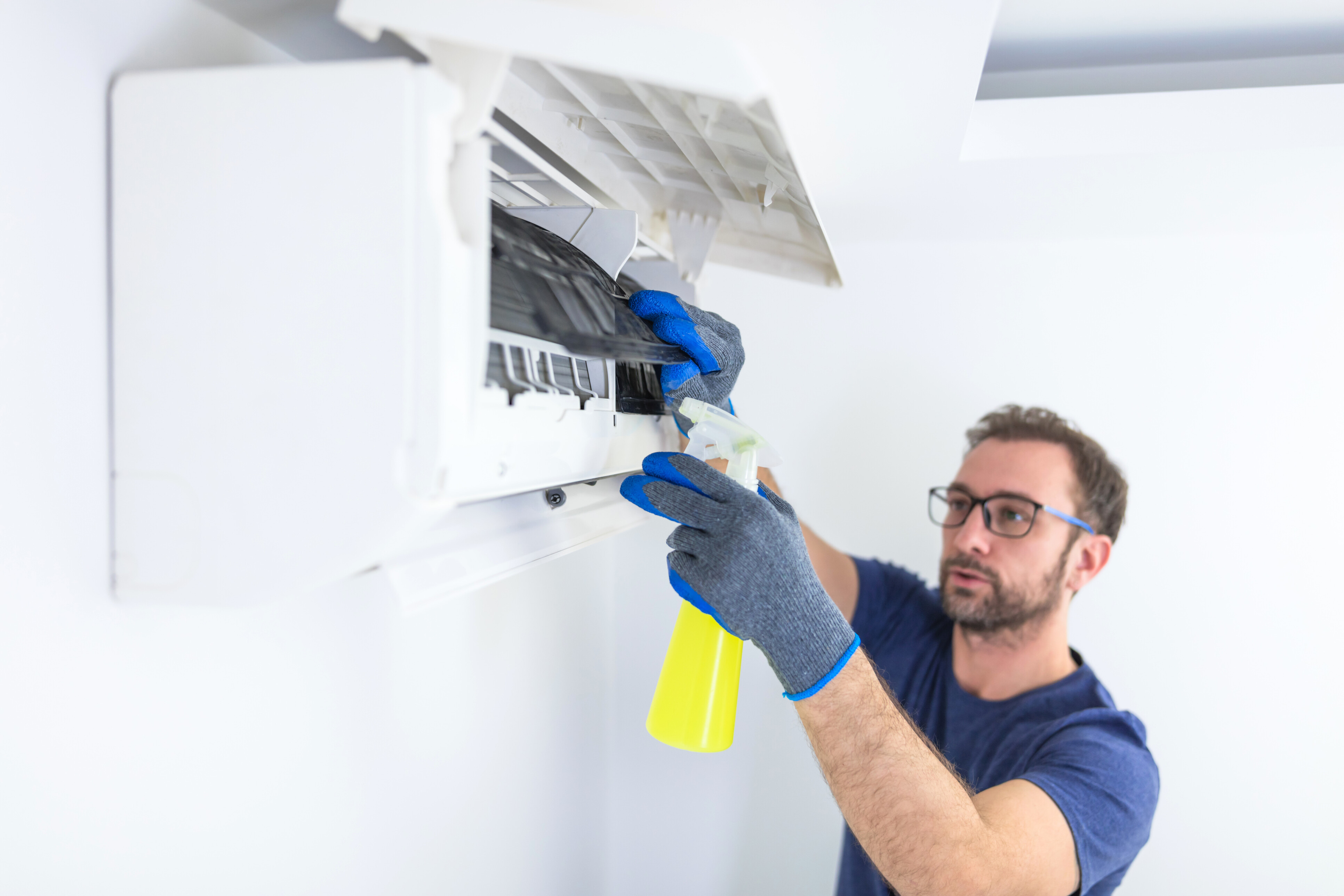 A man cleaning an air conditioner.