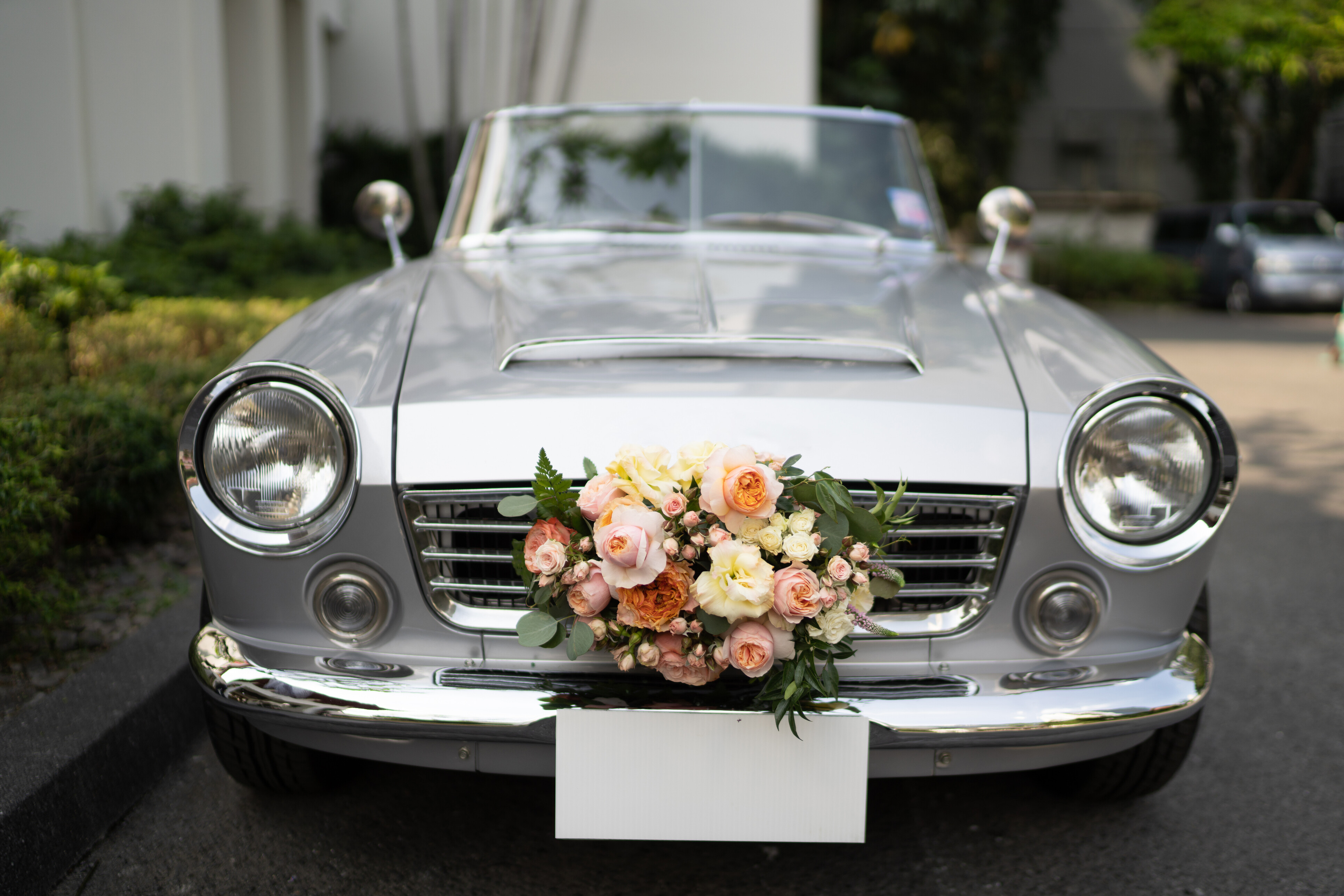 A wedding car rental with flowers on the car's grill.