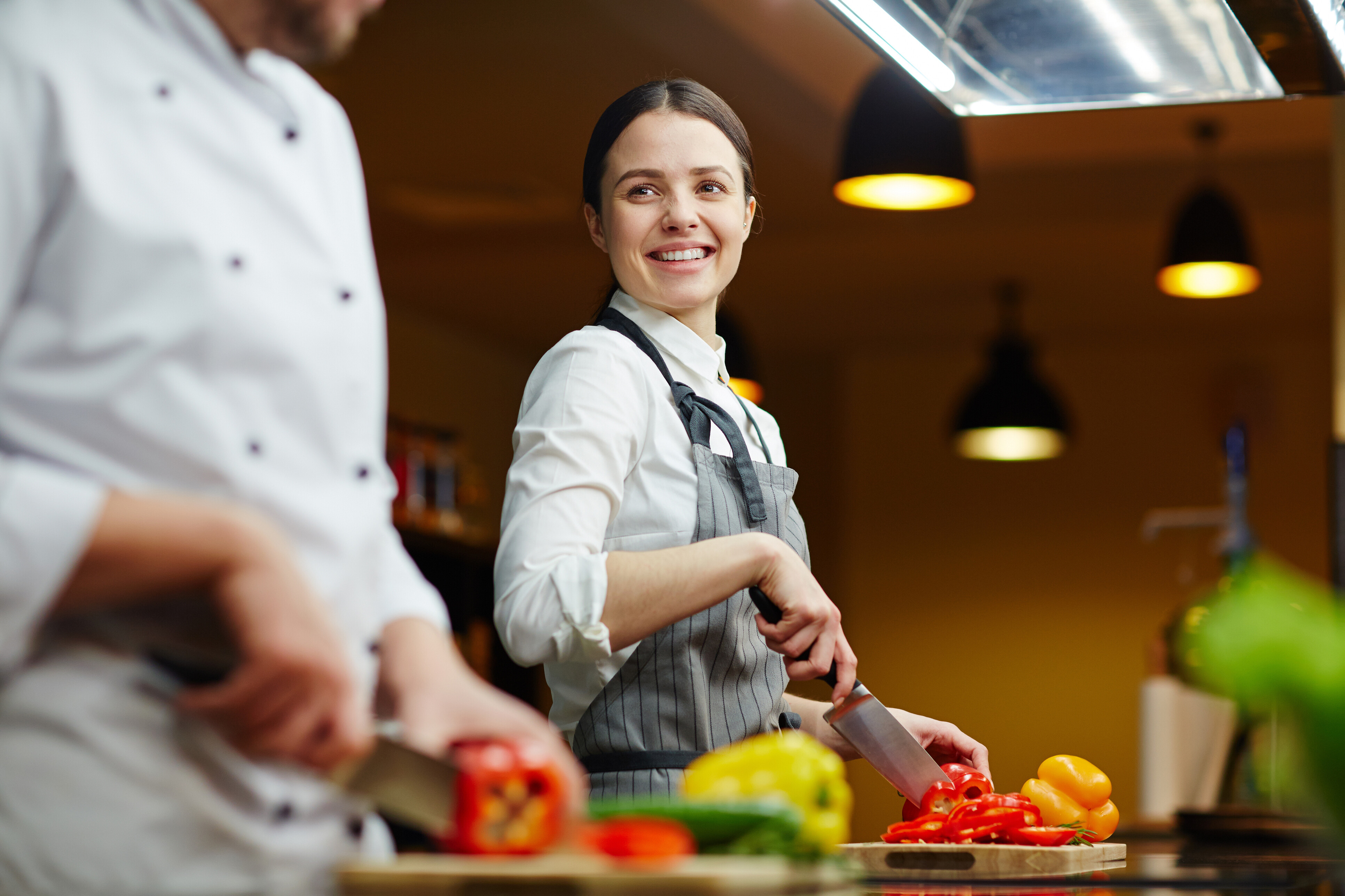 A prep cook preparing a meal and cutting vegetables.