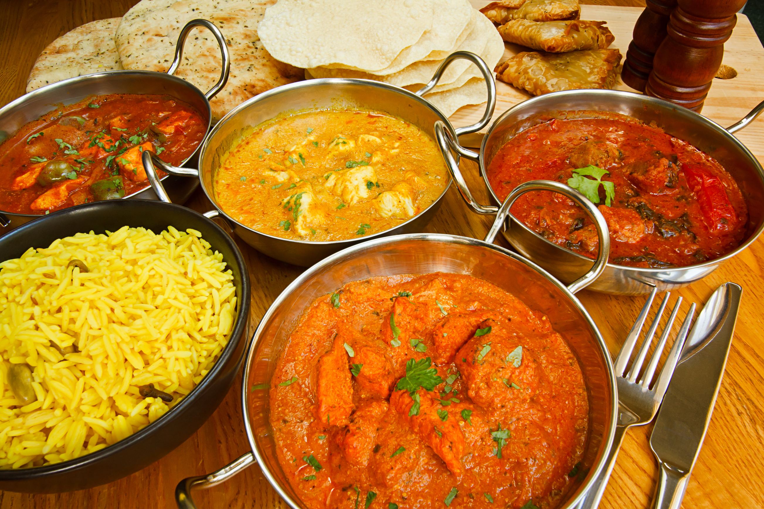 Indian food is on a table and ready for delivery and take out.