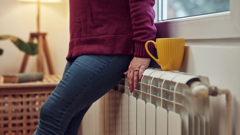 Underfloor heating vs radiators - A person heating on a chilly winter day