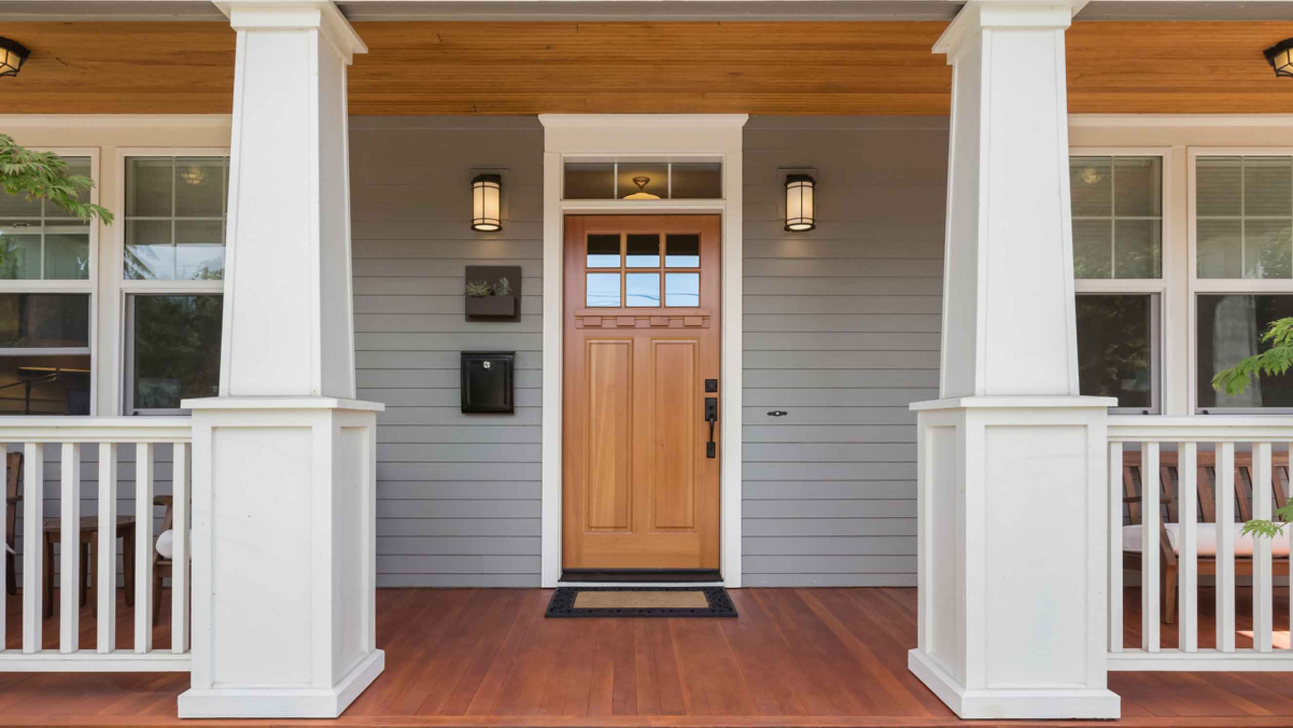 Wall cladding vs. wall paneling - Modern wall cladding applied to the exterior of a home with a covered porch and entrance door